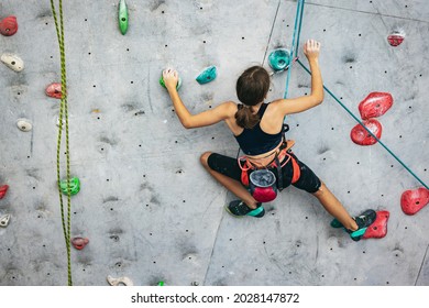 Little hiker. Portrait of active teen girl climbing the grey rock wall. Sport weekend action in adventure park. Active lifestyle concept - Powered by Shutterstock