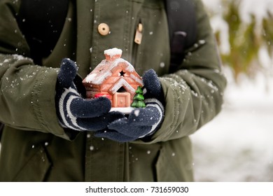 Little House In Children's Hands In Winter Outside.