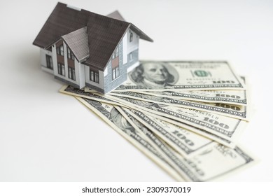 little house model with many dollar banknotes and keys. Real estate insurance. Investment - Powered by Shutterstock