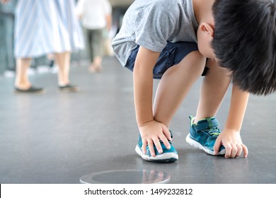 A Little Hyperactive Child Bend Down His Body Fidgeting In The Walkway. Behavioural Disorders, Autism, Attention Deficit, Oppositional Defiant, Disruptive Behaviour, Disobedient Child, Parenting.