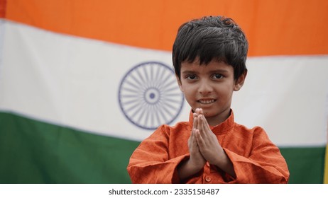 Little Indian boy celebrate the Auspicious Day - Independence Day Or Republic Day, Indian Model. Charming boy standing in a namaste position with a tricolor background, facing towards the camera