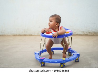 Little Indian Child In The Baby Walker Looking To Side