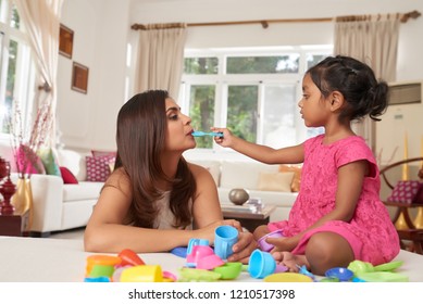 Little Indian Girl Feeding Her Mother With Invisible Food When That Are Playing Tea Party