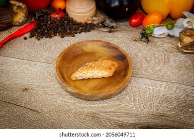 Little Italian cake on a little wooden plate, with food decorations in background.