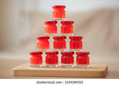 Little Jars With Homemade Grapefruit Marmalade, On A Wooden Board, With Grey Background