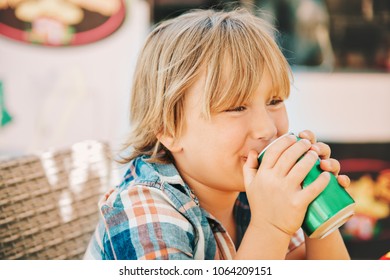 Little Kid Boy Drinking Soda In Cafe On A Very Hot Day