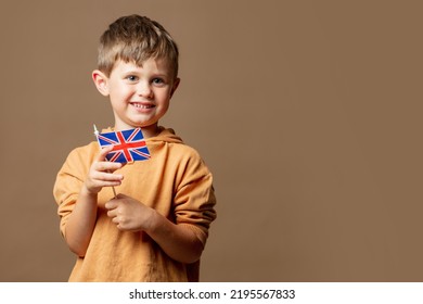 Little Kid Boy With GB Flag On Brown Background