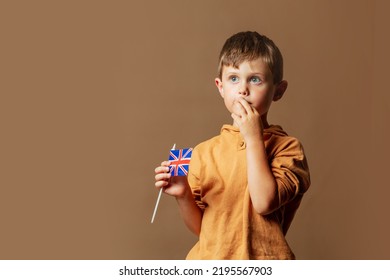 Little Kid Boy With GB Flag On Brown Background