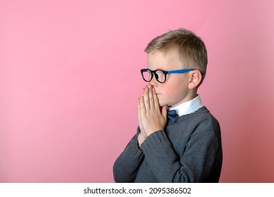 Little Kid Boy Praying, Child Put Hands In Asking Isolated On Pink Background. God Help Me.