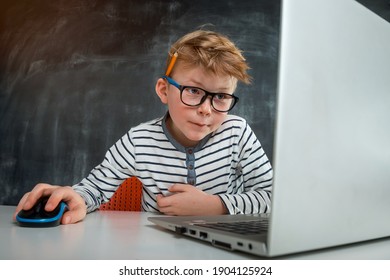 Little Kid Boy Programming With Laptop Computer. Close Up Of The Portrait Of Pupil In Blue Light Blocking Glasses. Child Codding. Computer Vision Syndrome. Online Education. IT Lessons.