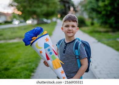 Little Kid Boy With School Satchel On First Day Of School, Holding School Cone With Gifts