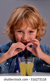 Little Kid Drinking Orange Soda With Straw.