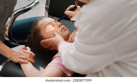 Little kid fainting in hospital waiting area, elderly doctor doing emergency consultation with flashlight. Worried woman supporting girl being sick and unconscious. Handheld shot. Close up. - Powered by Shutterstock