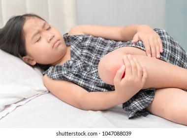 Little Kid Girl Feel Hurt And Pain, She Holds Her Knees. Healthy Problem