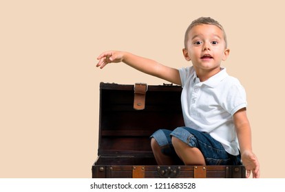 Little Kid Inside Treasure Chest On Color Baackground