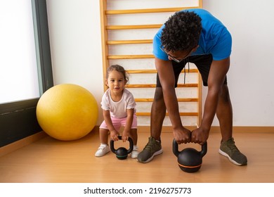 Little kid lifting kettlebell with father - Powered by Shutterstock