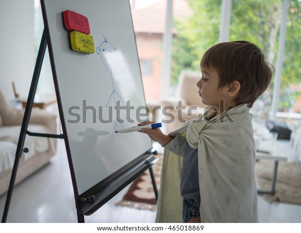 little boy painting on paintboard
