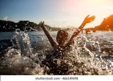 Little Kid Play In Water And Making Splash; Child Swim In Lake Or River And Have Fun With Drops;