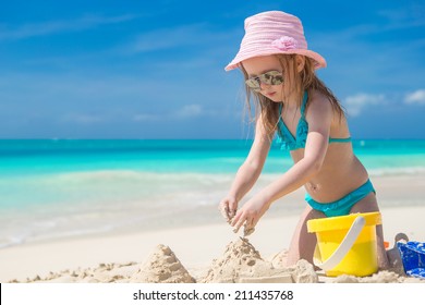 Little kid playing with beach toys during tropical vacation