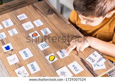 Little kid playing with cards of words and pictures. Time to learn. Education concept.