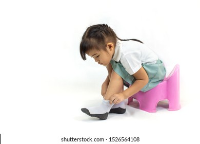 Little Kid Practice Put On The Socks And Shoes To Dressing By Herself. Learning To Do Activity Daily Living Help The Kids Developt Their Self Esteem And Confident.Picture Isolated On White Background.