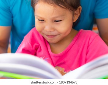Little kid reading a book at home. Children learning at home