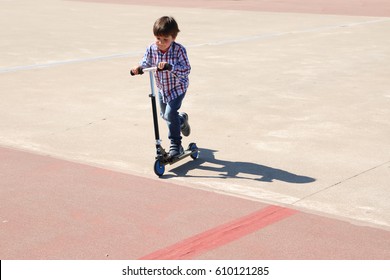 Little Kid Riding In His Scooter