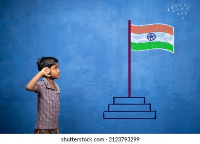 Little Kid Saluting Be Seeing Indian Flag On Wall - Concept Of Patriotism, Poverty And Independence Day Celebration In India