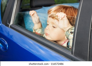 Little Kid Is Sitting Sad On The Back Sit And Look Tired Of Car Trip