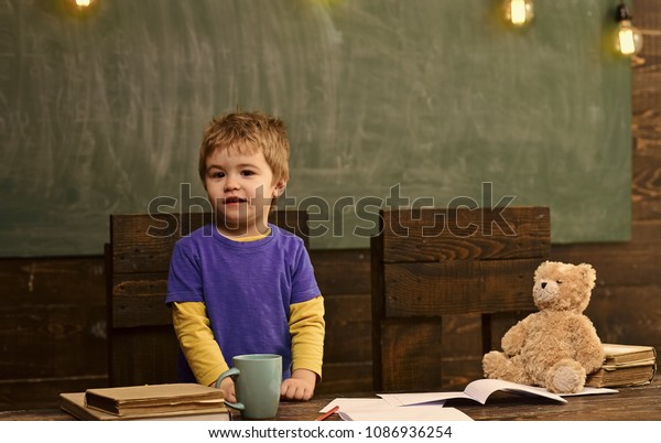 Little Kid Standing Behind Wooden Desk Stock Photo Edit Now