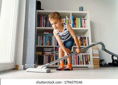 Little Kid Using Vacuum Cleaner At Home - Small Boy Cleaning Floor In Apartment - Child Doing Housework Having Fun - Side View Full Length In Summer Day - Childhood Development Real People Concept