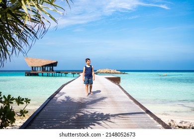 Little kid walking on a pathway over the ocean