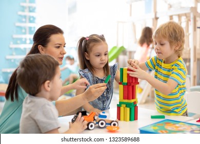 Little kids build wooden toys at home or daycare. Kids playing with color blocks. Educational toys for preschool and kindergarten children.