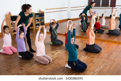 Little Kids Exercising With Female Teacher In Dance Class