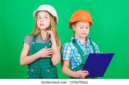 Little Kids In Helmet With Tablet. Labor Day. 1 May. Small Girls Repairing Together In Workshop. Foreman Inspector. Repair. School Project. Helmet And Tablet All You Need For Work.