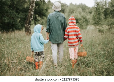 little kids mushroom pickers go to the forest or woodland by the hand with their grandmother. family of survivalists gathers a wild fungus harvest and outdoor foraging  in nature. rear view and behind - Shutterstock ID 2127973598
