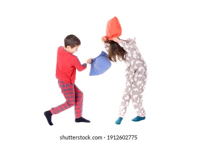 little kids on their pajamas having pillow fights isolated in white