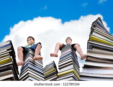 Little Kids Sitting On Large Stack Of Books