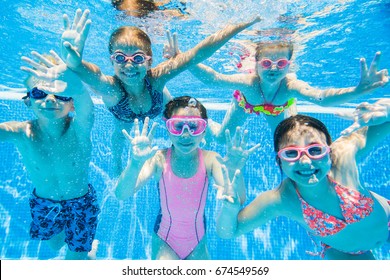 kleine Kinder schwimmen im Pool unter Wasser.