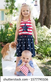 Little Kids Wearing 4th Of July Outfits Playing Cornhole With Family In Backyard On Fourth Of July