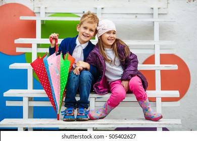 Little Kids Wearing Stylish Clothes On The Wooden White Stairs. Fashion Kid Concept.