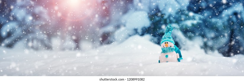 little knitted snowmans on soft snow on blue background - Shutterstock ID 1208991082