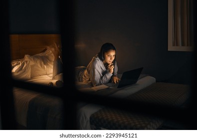 A little late night research. Cropped shot of an attractive young woman studying late at night in her bedroom at home.