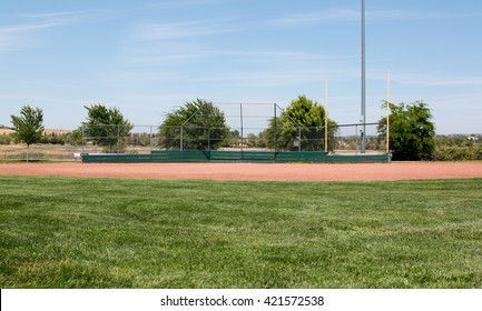 Little League Baseball Field With Green Grass, Brown Dirt And No People