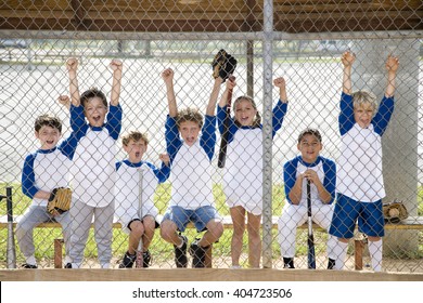 Little League Baseball Team Cheering Behind Wire Fence