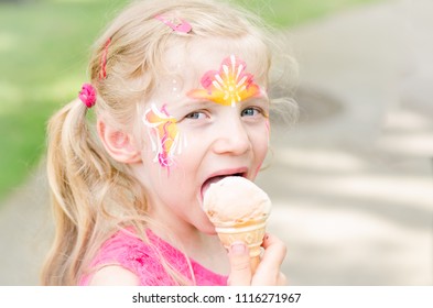 little lovely blond girl with colorful facepainting with ice cream - Powered by Shutterstock