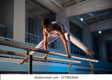 Little male gymnast training in gym, flexible and active. Caucasian fit little boy, athlete in white sportswear practicing in exercises for strength, balance. Movement, action, motion, dynamic concept - Powered by Shutterstock