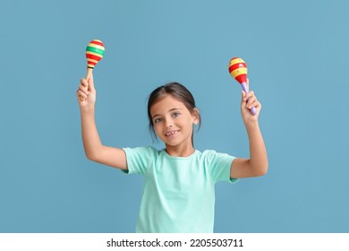 Little Mexican girl with maracas on blue background - Powered by Shutterstock