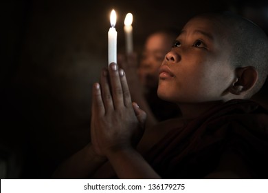 Little monks praying with candlelight