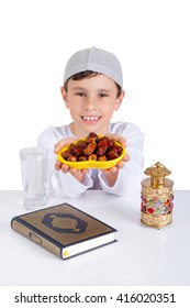 Little Muslim Kid Smiling While Presenting A Dish Of Dates For Iftar - Breaking Fast In Holy Ramadan - Showing Generosity Of Ramadan
